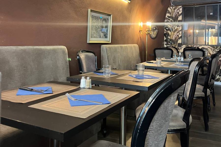 Tables dressées sous la voûte de La Marquise, nappes bleues et candélabre
